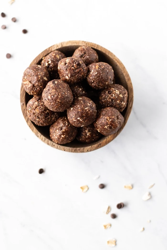 chocolate truffles, with nuts, in a wooden bowl, energy balls recipe, marble countertop