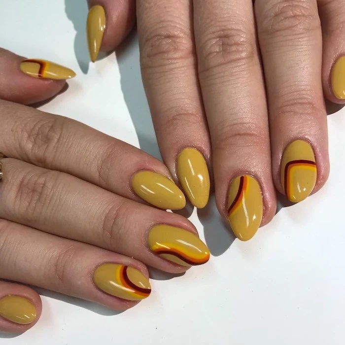 yellow nail polish, almond nails, september nail colors, yellow orange and red lines, nail decorations