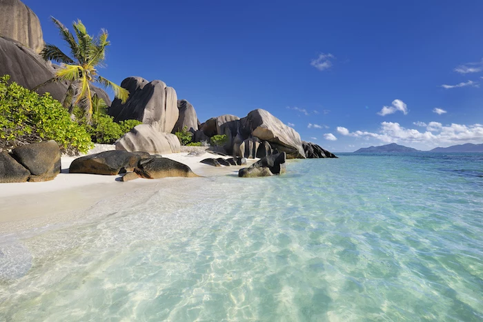 beautiful beaches, anse source d'argent beach on the seychelles, turquoise clear water, palm trees and rocks on the white sand