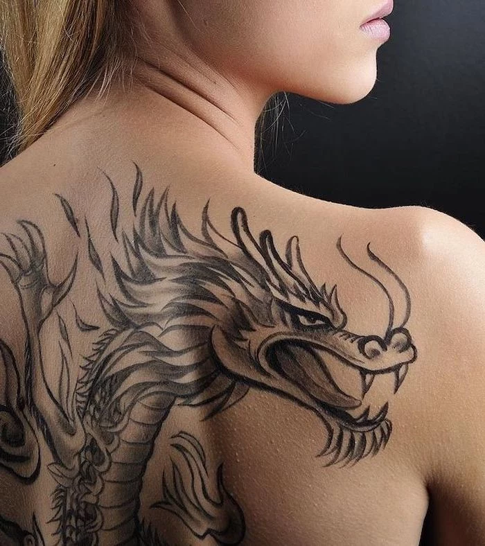 large back tattoo, on woman with blonde hair, dragon tattoo, black background
