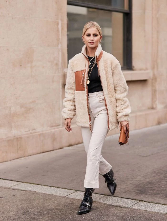 woman walking down the street, wearing white jeans and furry jacket, fashion trends, woman with blonde hair