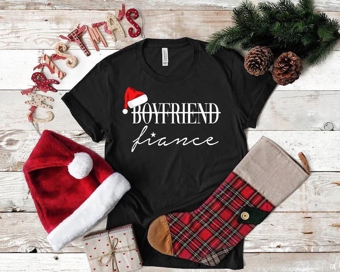 boyfriend fiance black t shirt, placed on wooden table, gifts for boyfriend, christmas hat and stocking next to it