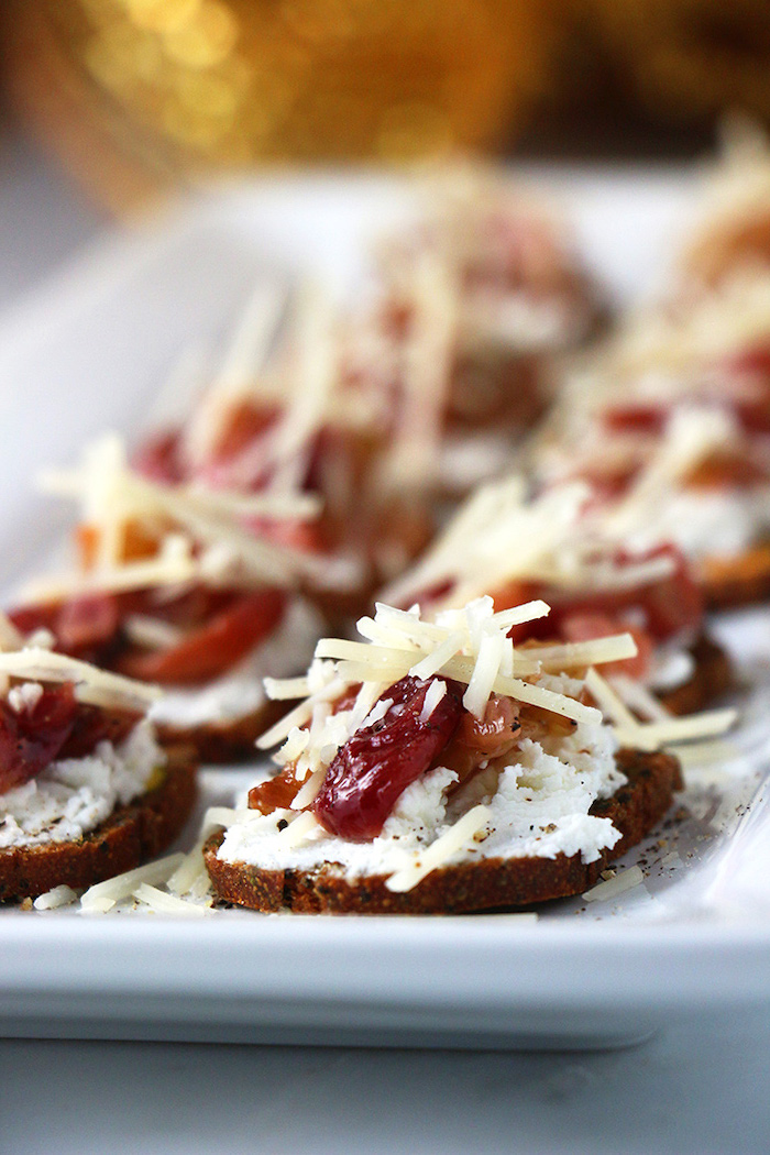 bruschetta with cream cheese, cranberries and shredded cheese, best appetizer to bring to a party, arranged on white plate