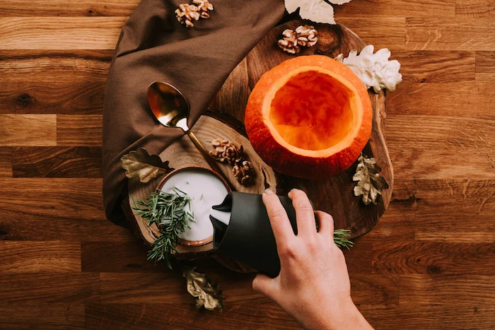 carved pumpkin, jug of milk, wooden board, fall leaves, arranged on wooden table, easy soup recipes, brown table cloth
