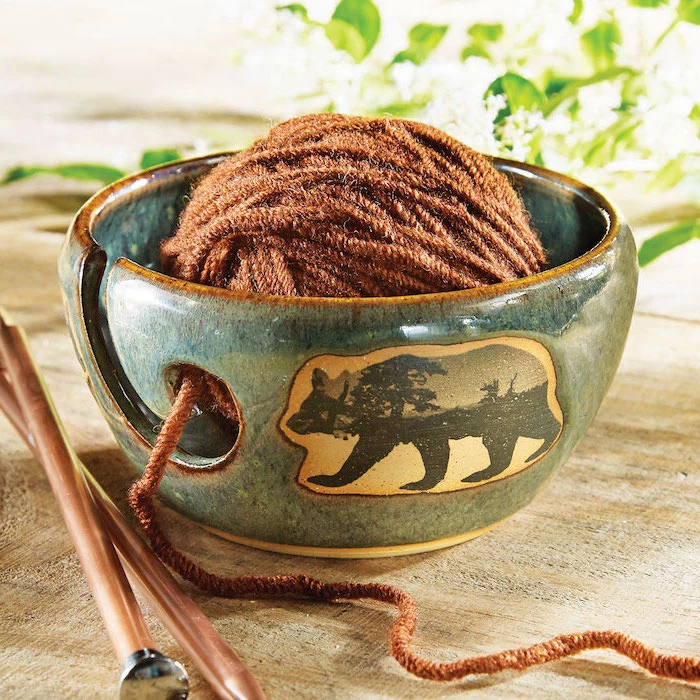 blue ceramic yarn bowl, with a bear picture on the side, brown yarn inside, christmas gifts for mom, needles on the side