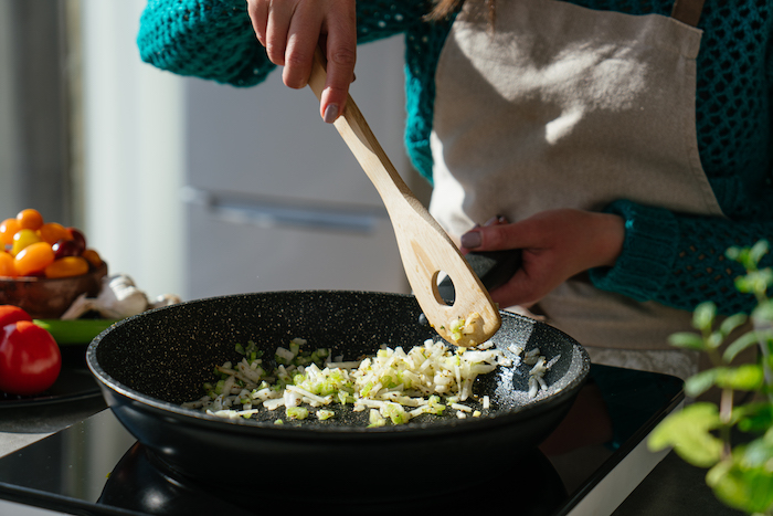 celery and onion cooked in black sauce pan, stirred with wooden spatula, tomato soup recipe