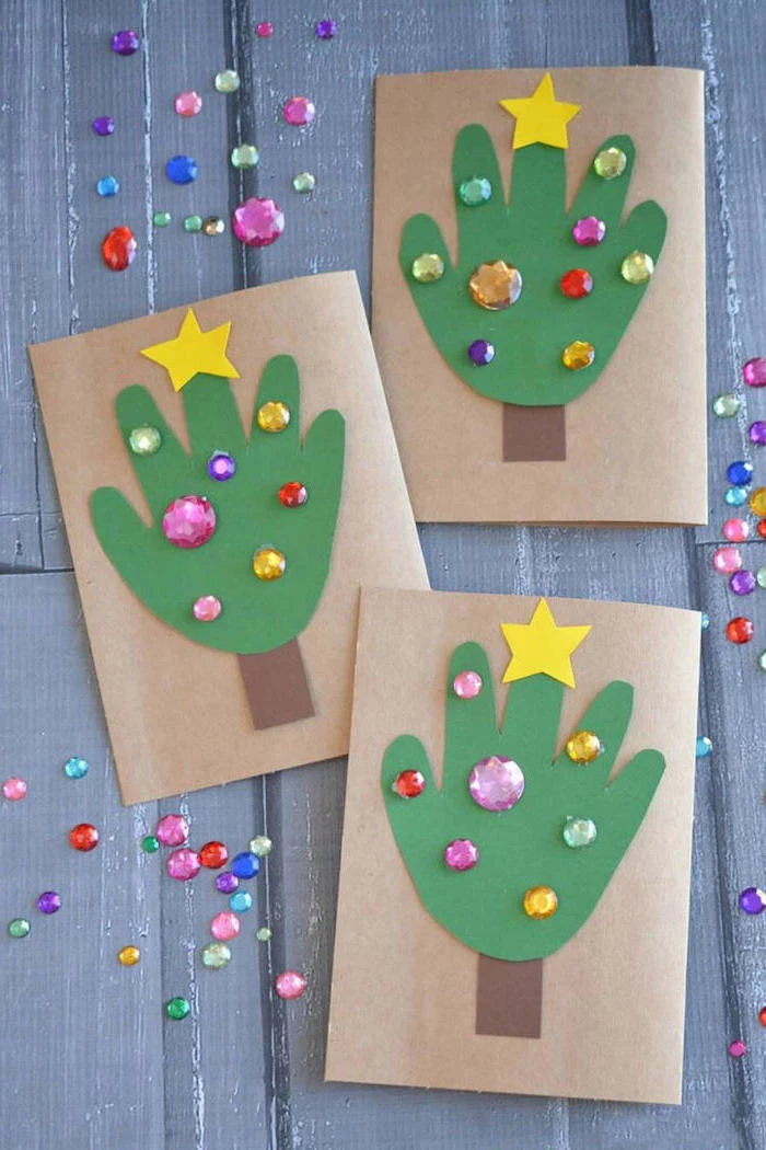 three christmas cards with handprints, cut out of green paper, christmas crafts for toddlers age 2 3, rhinestones on them