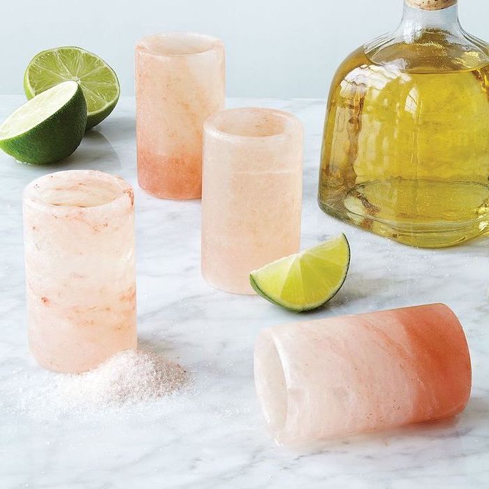 tequila shot glasses, made of himalayan salt, cute gifts for boyfriend, placed on marble surface, lime slices on the side