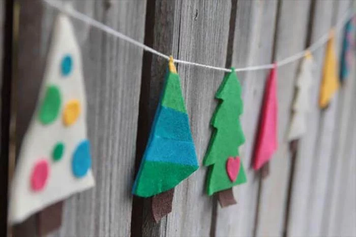 diy christmas crafts, garland of christmas trees made of felt, hanging on wooden wall