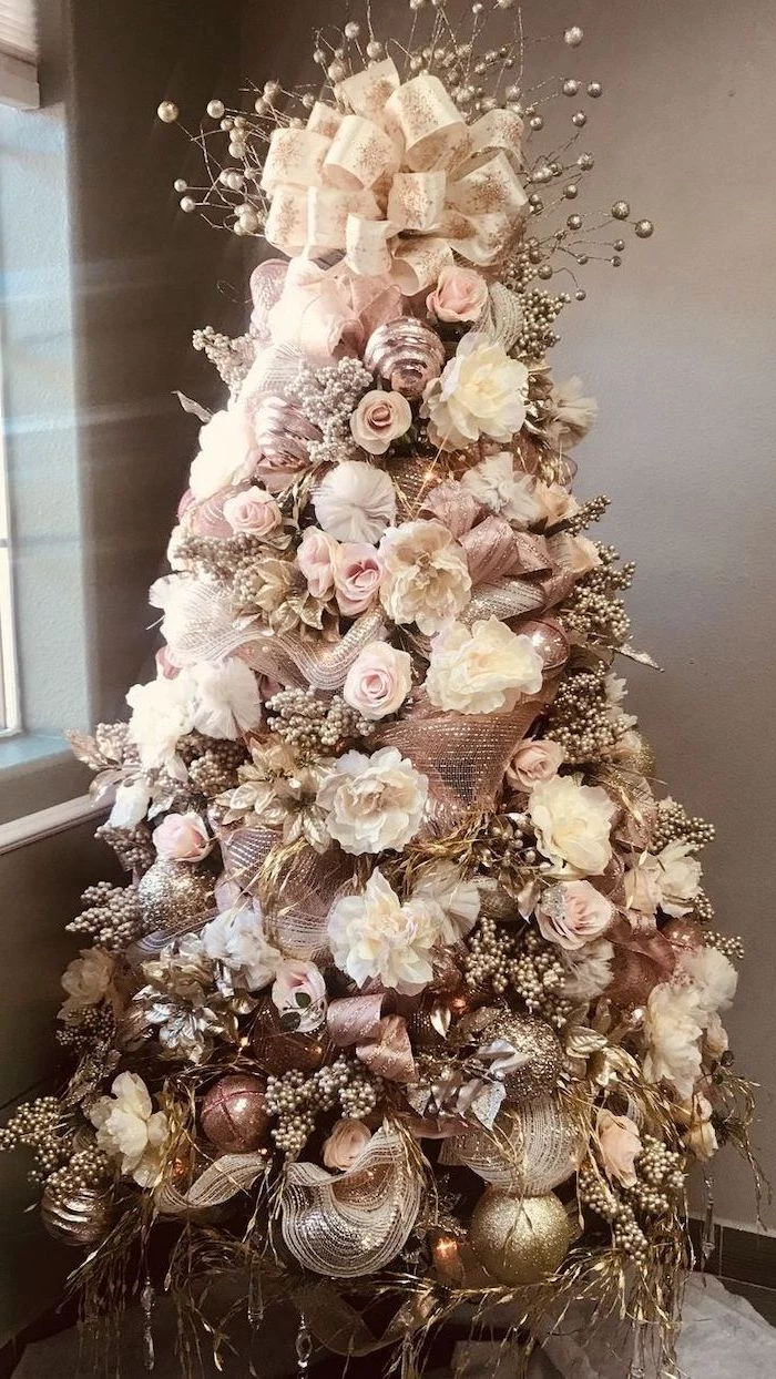 christmas tree ribbon, decorated with faux roses and flowers, rose gold ornaments and ribbons, large bow on top