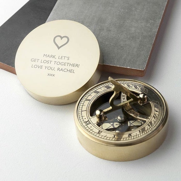 compass in a round golden box, personalised love message on top of the box, gift ideas for boyfriend, placed on white surface