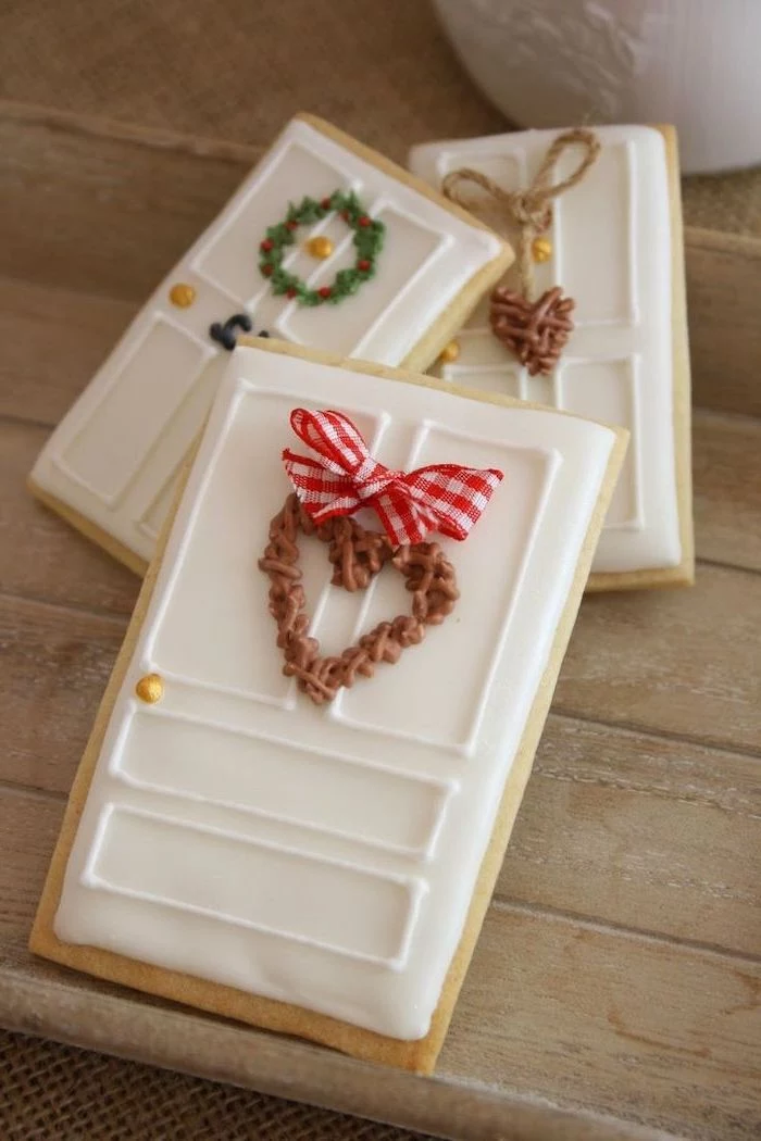 door shaped cookies, with wreath decorations on them, sugar cookie icing recipe, placed on wooden surface