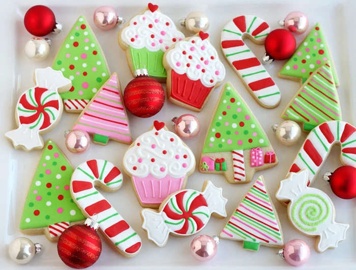 christmas cookie decorating ideas, cookies in different shapes, cupcakes candy canes and christmas trees, placed on white plate