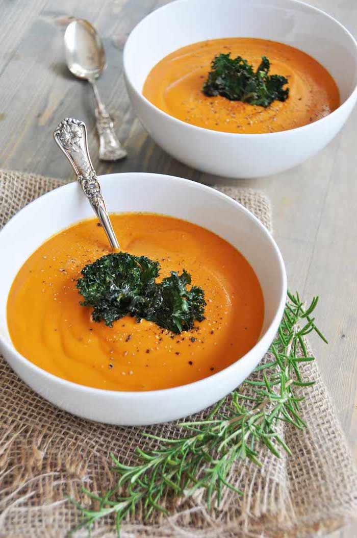 two white ceramic bowls full of soup, baked broccoli on top for garnish, creamy potato soup recipe, fresh rosemary on the side