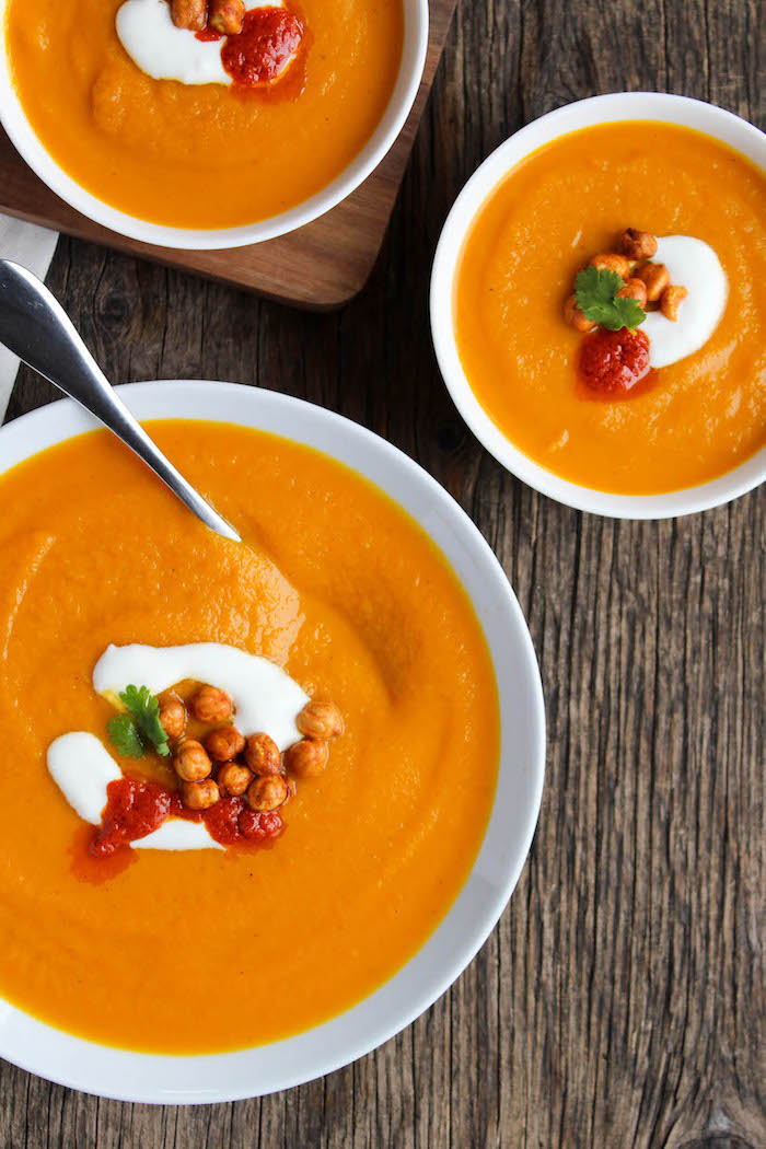 three white ceramic bowls full of soup, creamy potato soup recipe, chickpeas on top for garnish, wooden table