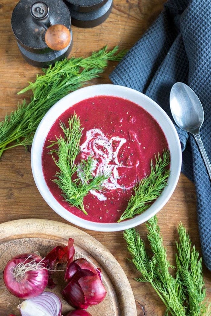 white ceramic bowl full of soup, fresh dill for garnish, chopped onion, wooden table, black table cloth, how to make soup