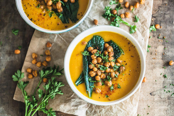 white ceramic bowl full of soup, chickpeas and fresh herbs on top for garnish, how to make soup, fresh parsley on the side