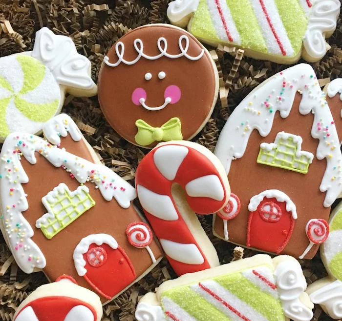 cookies in different shapes, decorated with colorful icing, placed on crepe paper, how to decorate sugar cookies
