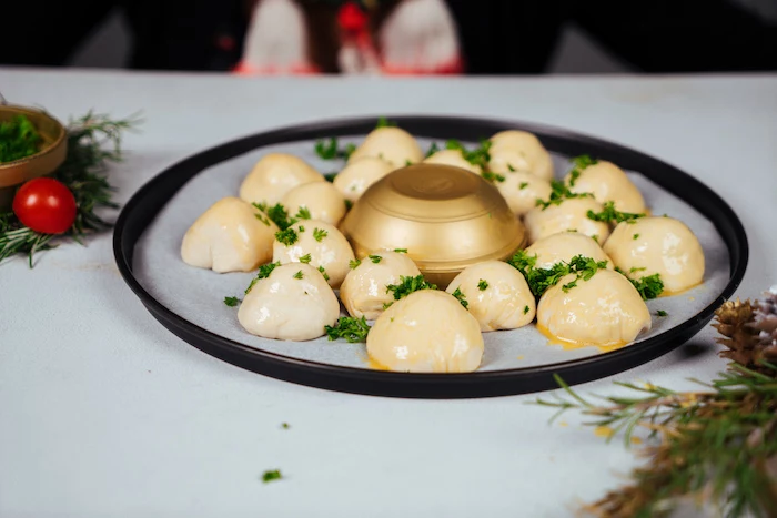 small dough balls, covered with chopped parsley, pull apart christmas bread, around a golden bowl, on baking sheet