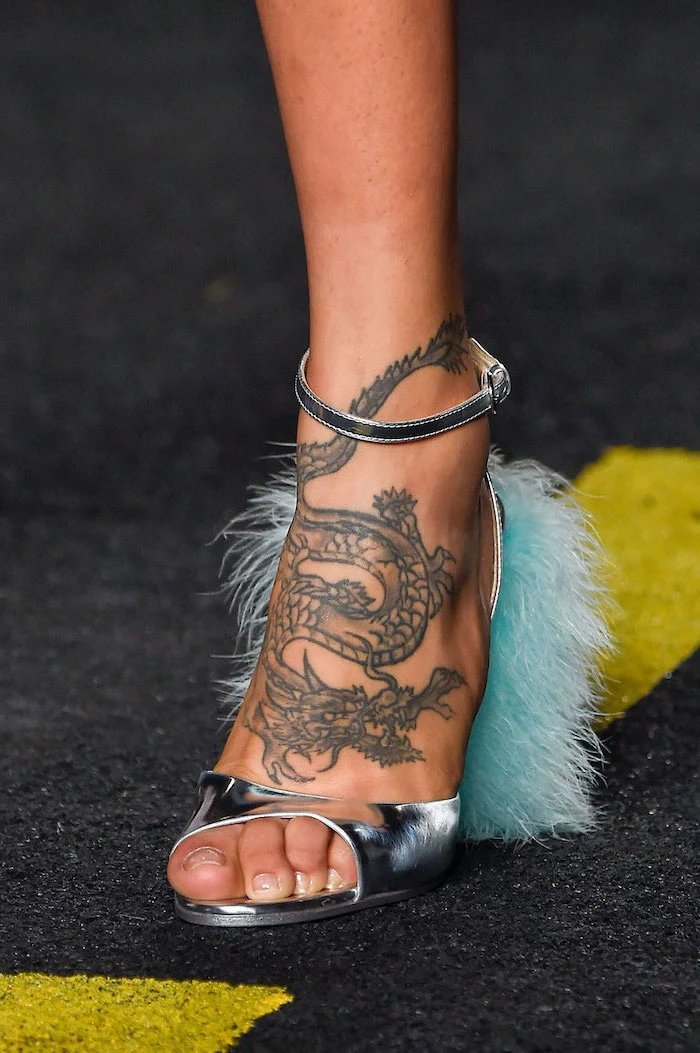 large dragon on the leg, woman wearing silver open toe heels with blue feathers, chinese dragon tattoo