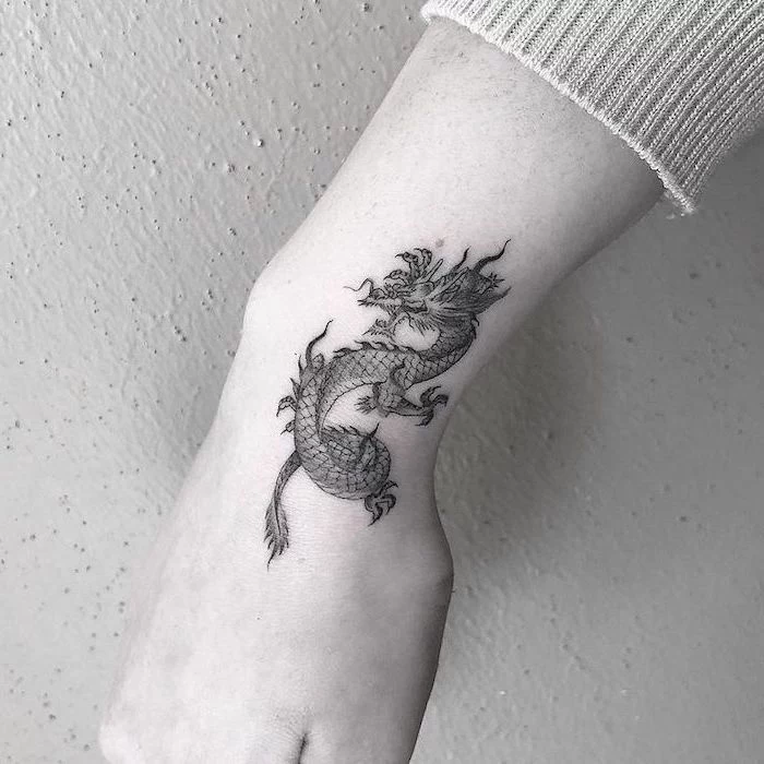 wrist tattoo, black and white photo, small dragon tattoos, white background