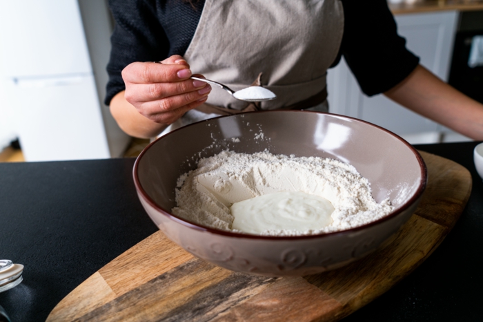 dry and wet ingredients, placed inside a ceramic bowl, placed on wooden cutting board, naan bread