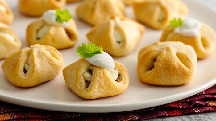 small puff pastries with brie cheese inside, sour cream inside, christmas appetizer recipes, arranged on white plate