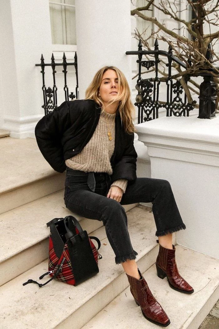 woman sitting on stairs, wearing black jeans and brown sweater, new fashion trends, black jacket and red leather boots