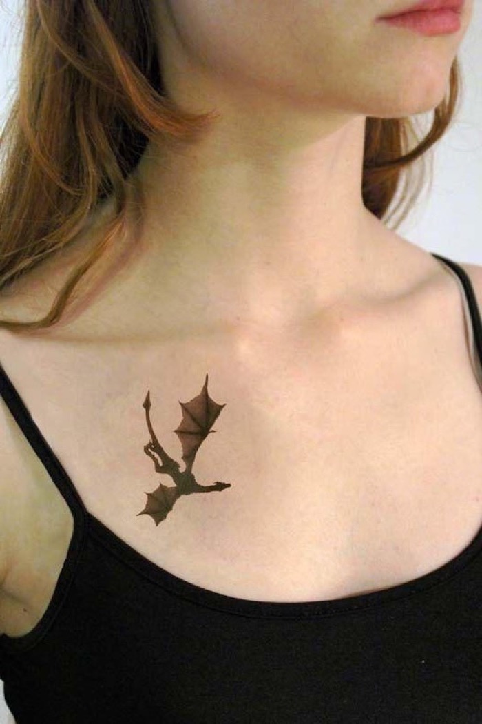 dragon arm tattoo, flying dragon, drogon from game of thrones, collarbone tattoo, woman with blonde hair, wearing black top