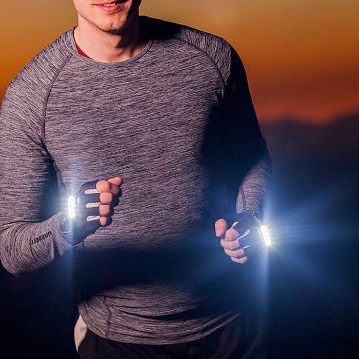 man wearing grey blouse, runner's led light gloves, what to get your boyfriend for christmas, sunset in the background