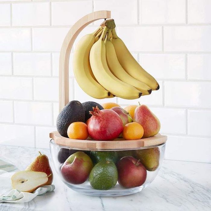 fruit bowl made of glass and wood, full of fruits, christmas gifts for mothers, placed on marble countertop