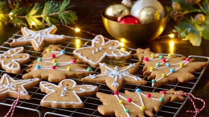 royal icing for decorating cookies, gingerbread cookies in different shapes, arranged on metal rail, snowflakes and angels