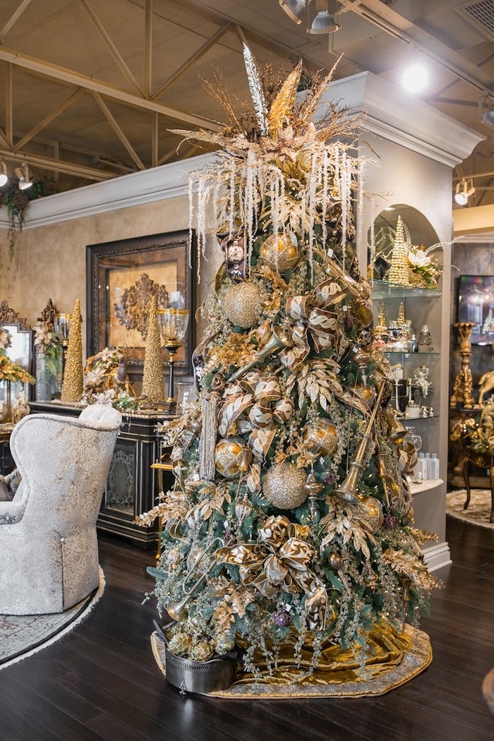 tree decorated with large gold and silver ornaments, colorful christmas tree, gold ribbon and bows, placed on gold rug