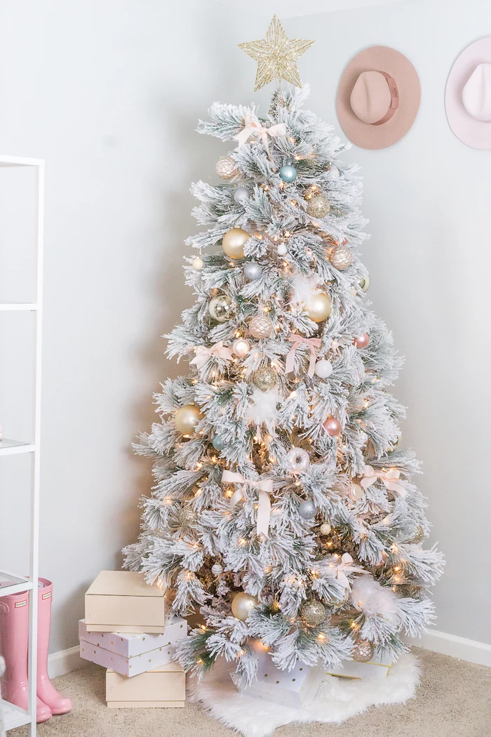 rose gold christmas tree, faux white tree, decorated with gold ornaments and pink bows, large gold star on top