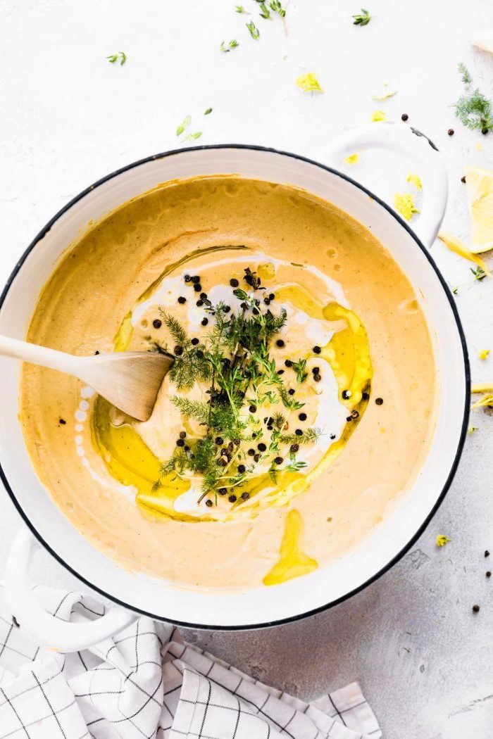 white pot full of soup, fresh dill on top for garnish, stirred with a wooden spatula, old fashioned potato soup