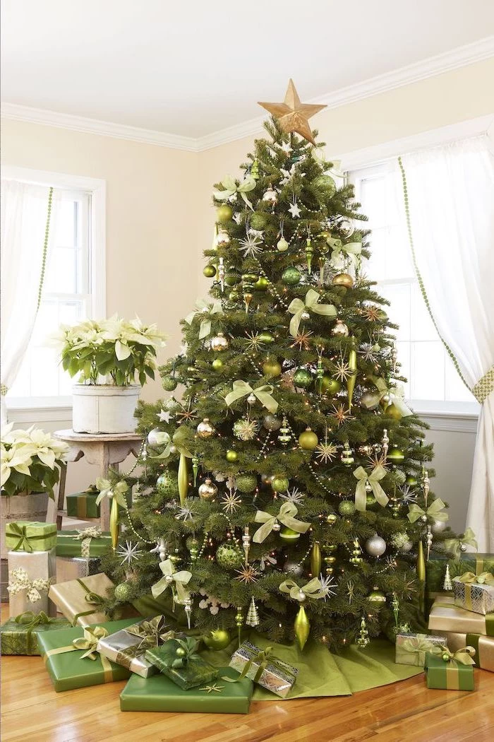 rustic christmas tree, gold star topper, tree decorated with green and silver ornaments, green bows, wrapped presents underneath