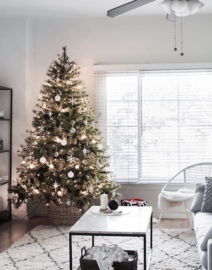 beautiful christmas trees, green tree with white ornaments and snowflakes, in wooden basket, with lots of lights