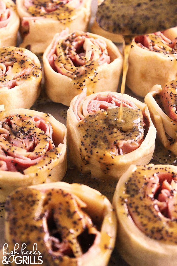 holiday appetizers, ham and cheese rolls, covered with sauce with poppy seeds