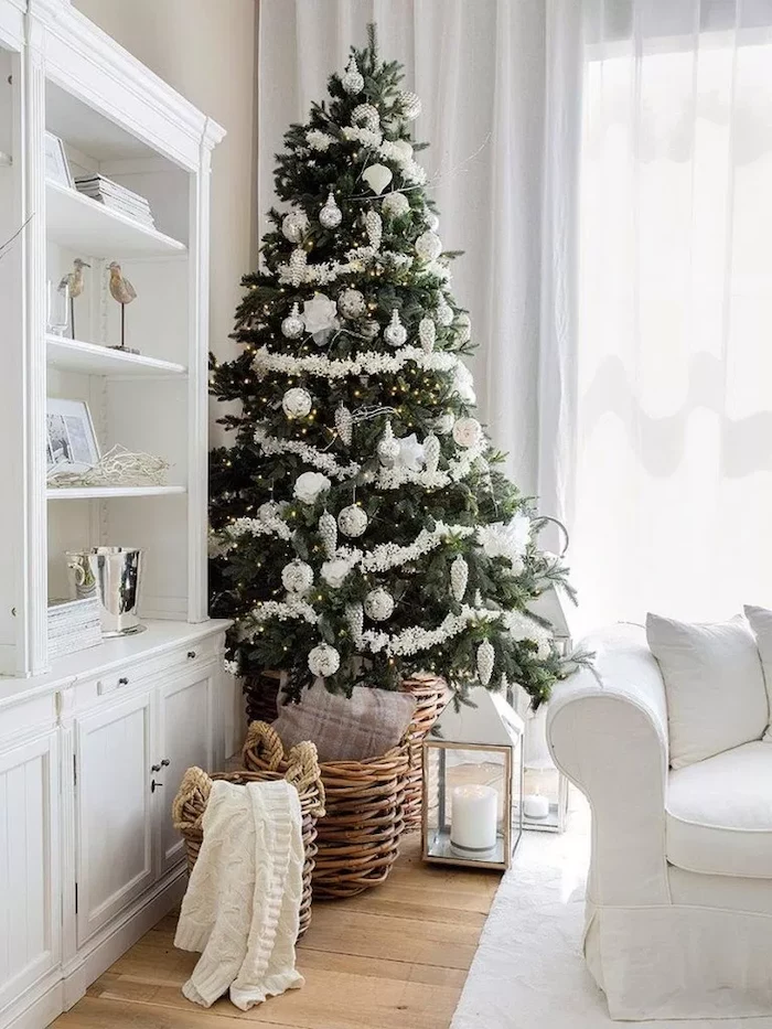 tall tree decorated with white garland, white and silver ornaments, beautiful christmas trees, placed in wooden basket