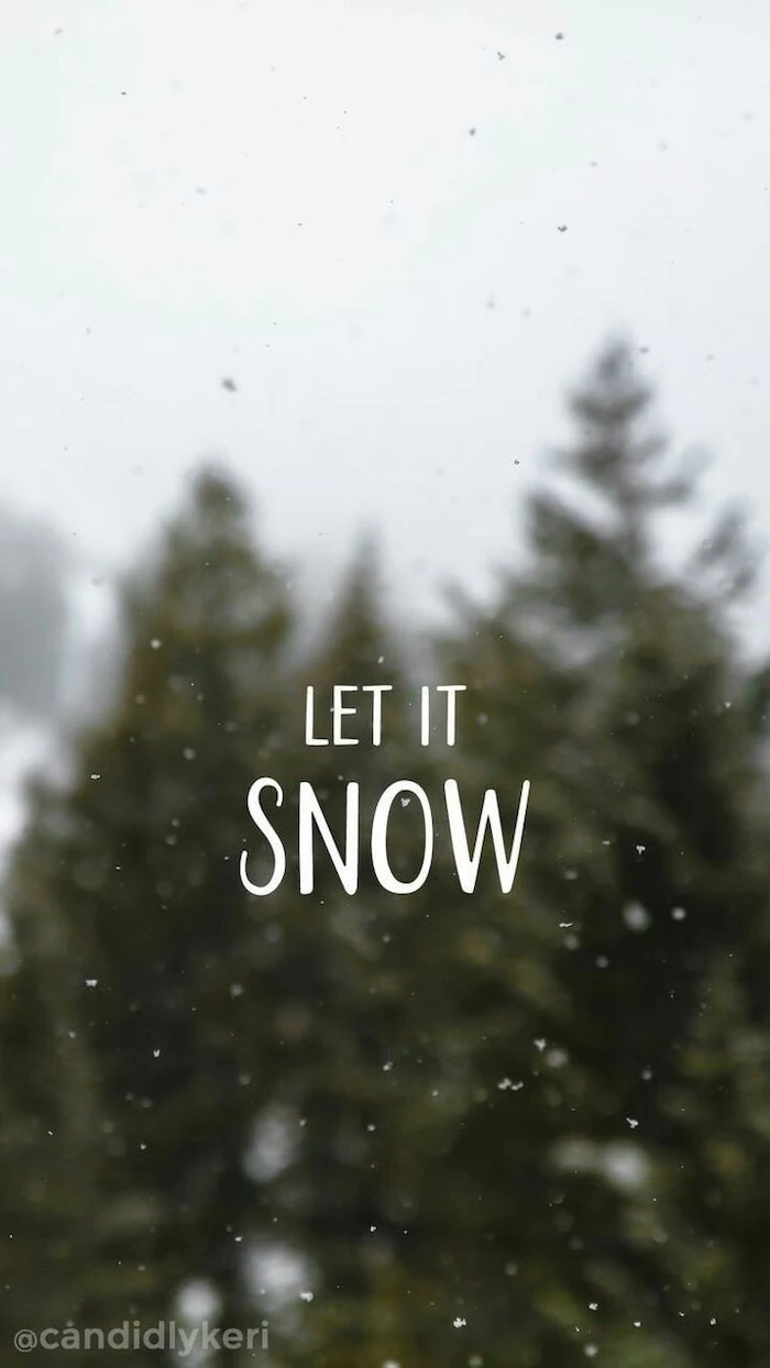let it snow written over blurred background, tall trees and snow falling, screen saver wallpaper