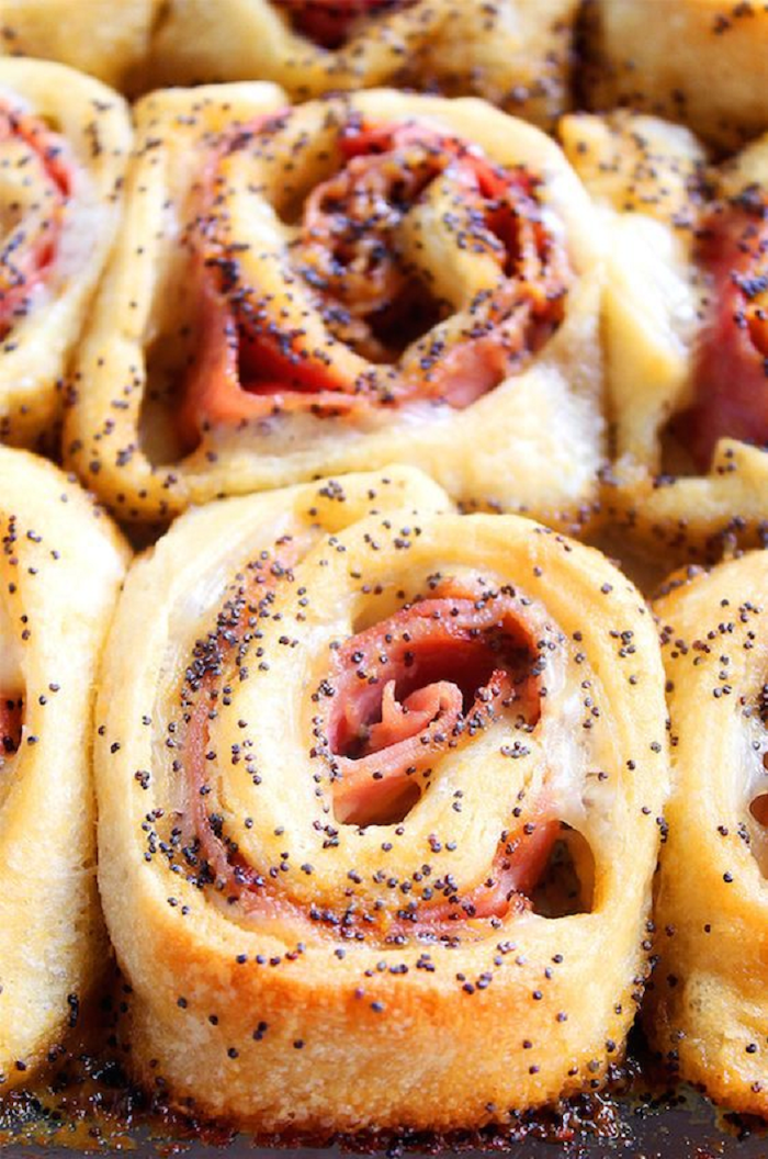 ham and cheese rolls, holiday appetizers, covered with sauce with poppy seeds
