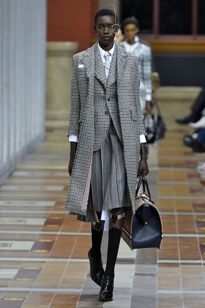 woman dressed in oxford style, all plaid grey suit, consisting of blazer coat and pleaded skirt, 2019 clothing trends