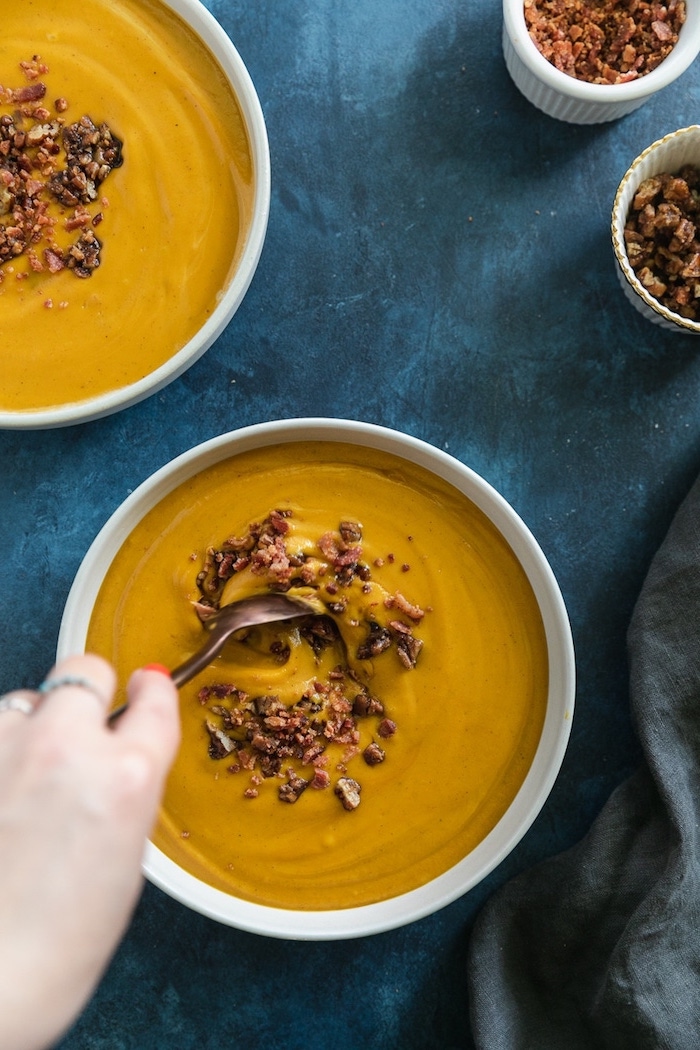 two white ceramic bowls full of soup, pecans on top for garnish, homemade cream of chicken soup, blue table