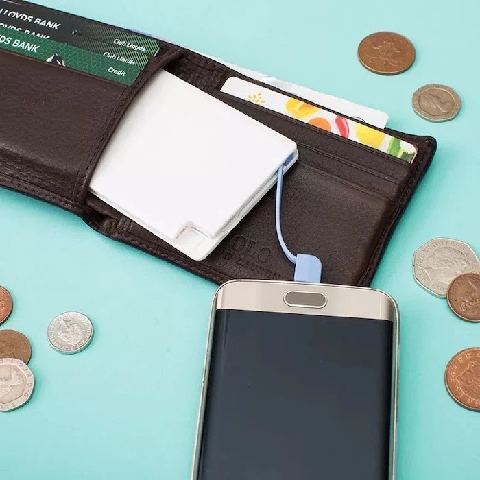 white power bank fitting inside a wallet, creative gifts for boyfriend, coins scattered around turquoise surface