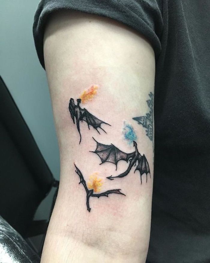 three dragons flying, drogon viserion and rheagal from game of thrones, what does a dragon symbolize, inside arm tattoo