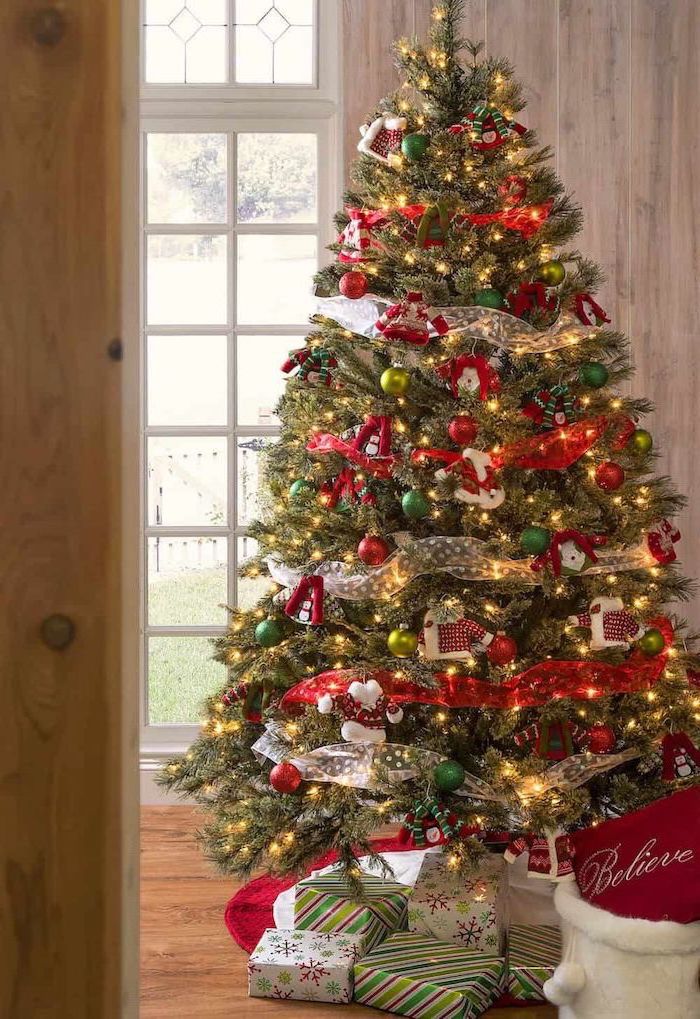 gold ribbon wrapped around a tree, decorated with green and red ornaments, elegant christmas tree decorating ideas