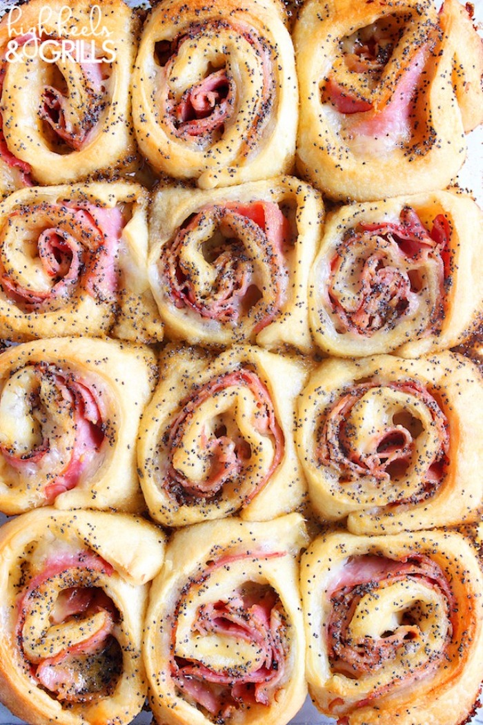 ham and cheese rolls, covered with sauce with poppy seeds, finger foods for party