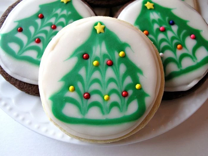 how to make icing for cookies, round cookies with green and white icing, christmas tree drawn on them with icing