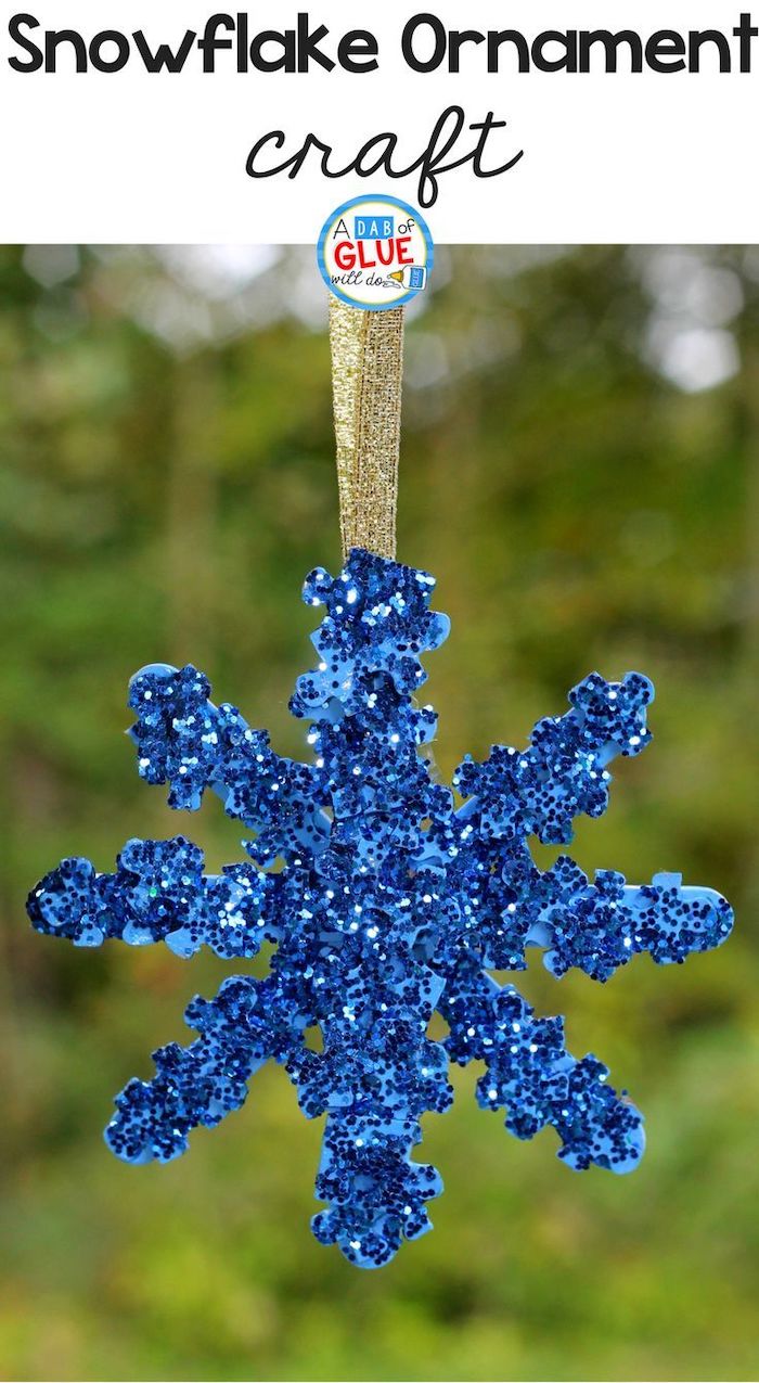 snowflake ornament craft, homemade christmas crafts, made of jigsaw puzzle pieces and blue glitter