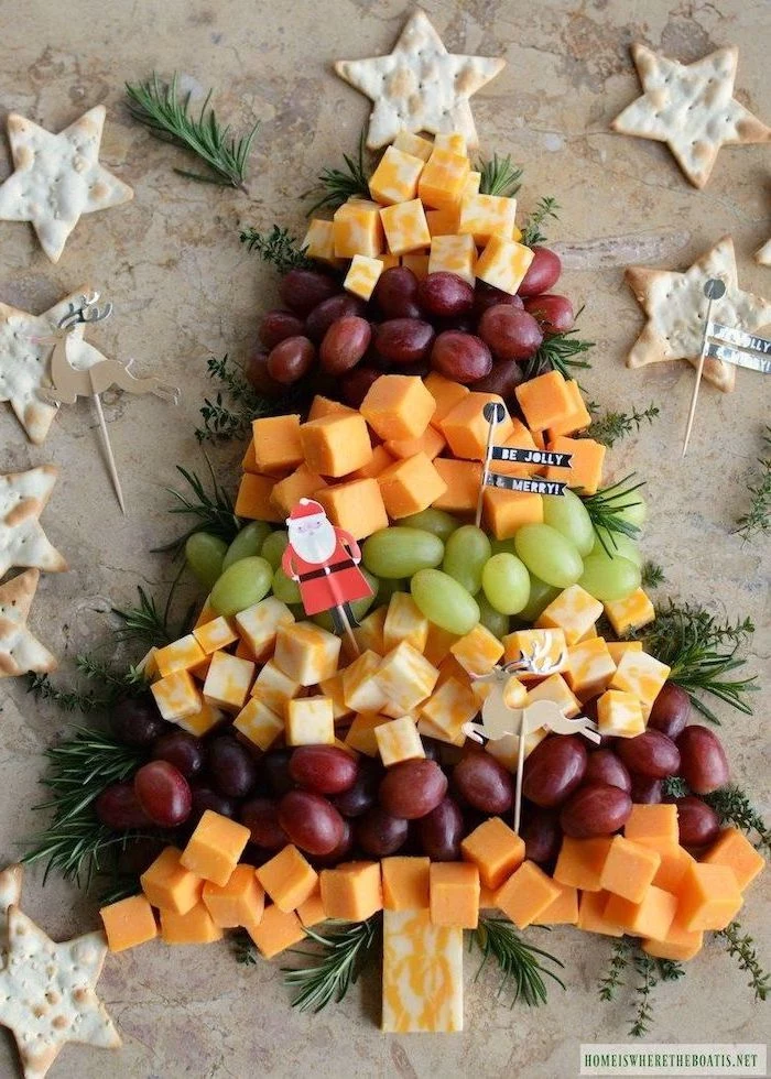 christmas tree made of grapes, different types of cheese, rosemary branches, christmas eve appetizers, star shaped crackers